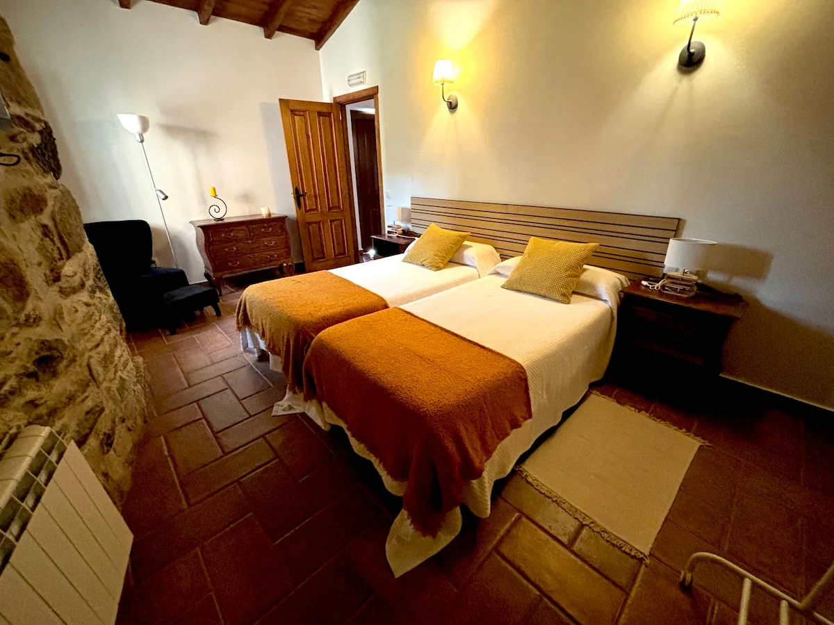 Bedroom of the 1371 apartment with two beds and mustard bedspreads